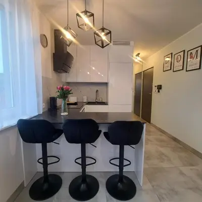 a kitchen with a table and two stools in a kitchen at Apartament Gotowizna in Wadowice