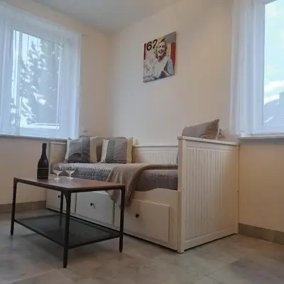 a small room with a bed and a table at Apartament Gotowizna in Wadowice