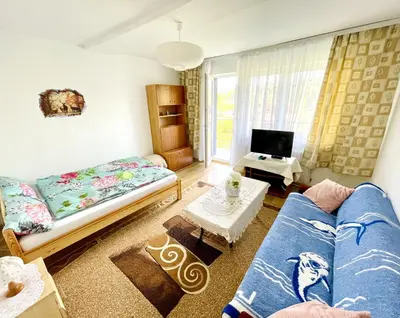 a kitchen with tables and chairs and a refrigerator at Przytulne Apartamenciki tuż przy Termach i Parku, nieopodal szlak na Turbacz, GPN, KGP in Poręba Wielka