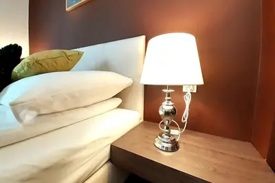 a lamp sitting on a table next to a bed at Luxury Apartment - Rakowicka R15 in Kraków