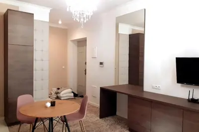 a living room with a table and a mirror at Luxury Apartment - Rakowicka R15 in Kraków
