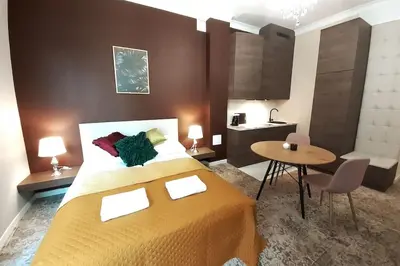 a bedroom with a large bed and a small table at Luxury Apartment - Rakowicka R15 in Kraków