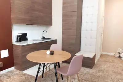 a small kitchen with a wooden table and chairs at Luxury Apartment - Rakowicka R15 in Kraków