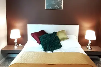 a white bed with pillows on it with two lamps at Luxury Apartment - Rakowicka R15 in Kraków