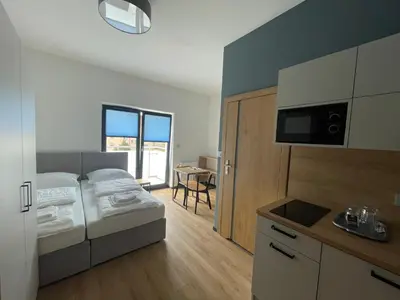 a hotel room with a bed and a kitchen with at Rent Apartment in Wieliczka