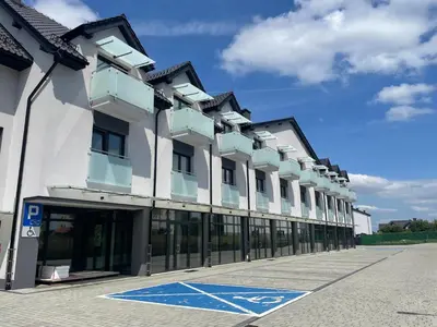 a large white building with windows on a street at Rent Apartment in Wieliczka