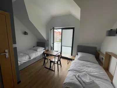 a bedroom with a bed and a desk and a table at Rent Apartment in Wieliczka