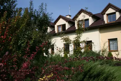 a white house with a black roof at Pensjonat B&B Nad Rudawą in Kraków