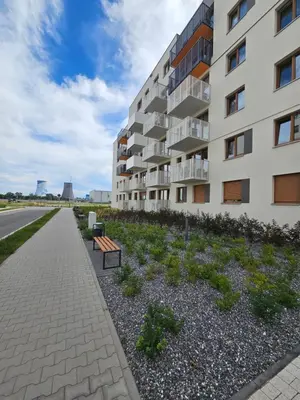 an apartment building with a garden in front of it at Apartament Centralna Park in Kraków
