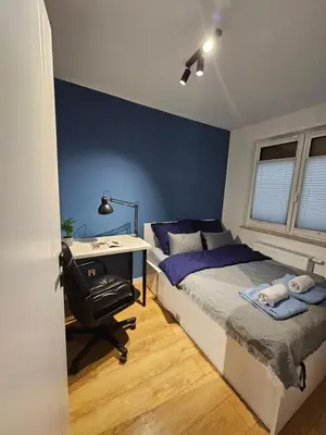 a bedroom with a bed with a desk and a bed sidx sidx sidx at Apartament Centralna Park in Kraków