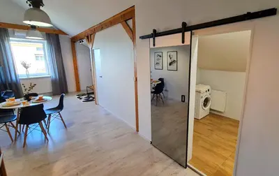 a living room with a dining room table and a mirror at Apartament Quiet Street 11, 6E in Oświęcim
