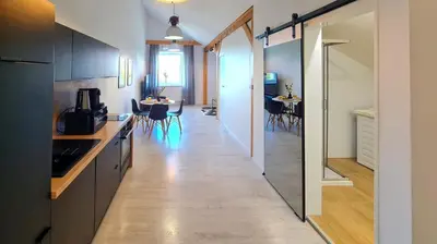 a kitchen with black cabinets and a dining room at Apartament Quiet Street 11, 6E in Oświęcim