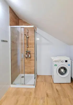 a shower in a bathroom with a washing machine at Apartament Quiet Street 11, 6E in Oświęcim