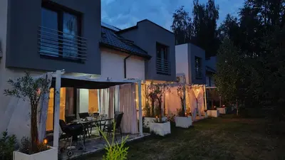 a house with a table in a backyard at night at Apartament Miętowe Marzenie in Chrzanów