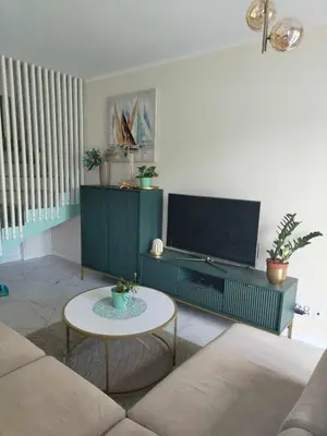 a living room with a tv and a table at Apartament Miętowe Marzenie in Chrzanów