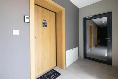 a hallway with a wooden door with a sign on it at Ap with a balcony- Podgorze- Kalwaryjska 34 in Kraków