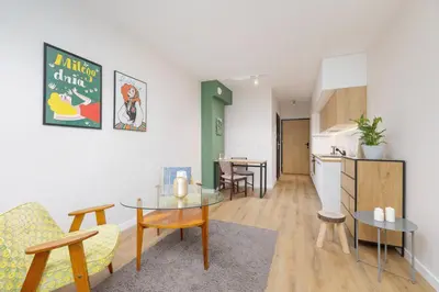 a living room with a table and a kitchen at Ap with a balcony- Podgorze- Kalwaryjska 34 in Kraków
