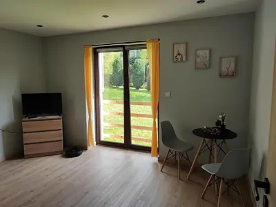 a living room with a sliding glass door with a table and chairs at Apartamenty pod groniem in Sułkowice