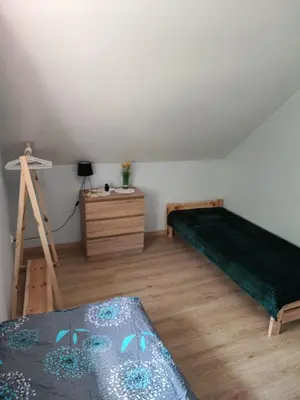 a bedroom with two beds and a dresser at Apartamenty pod groniem in Sułkowice