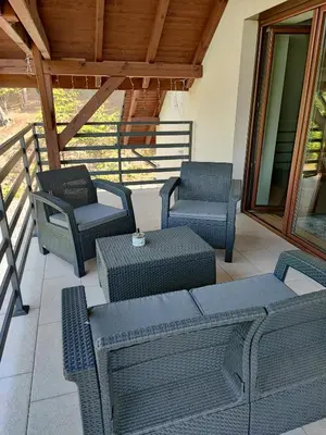 a patio with four chairs and a table and chairs at Apartamenty pod groniem in Sułkowice