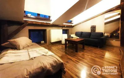 a bedroom with a bed and a couch and a table at A Stone's Throw Apartment in Kraków