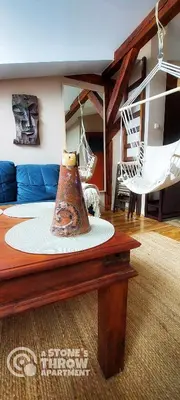 a room with a table with a vase on top of it at A Stone's Throw Apartment in Kraków