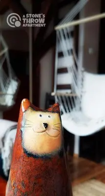 a vase with a painting of a cat on it at A Stone's Throw Apartment in Kraków
