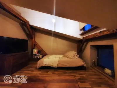 a bedroom with a bed and a tv in a room at A Stone's Throw Apartment in Kraków