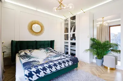 a bedroom with a bed with a green headboard at Mozarta sky terrace VIP 2-bed apartament in Kraków
