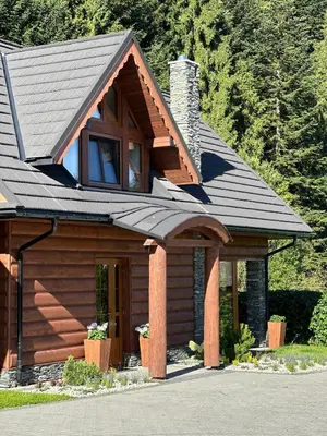a log cabin with a gambrel roof at Leśna Przystań Gorce in Nowy Targ
