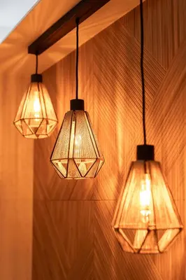 a group of three lights hanging from a wall at Leśna Przystań Gorce in Nowy Targ
