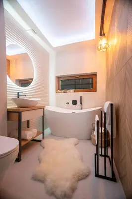 a bathroom with a large white tub and a sink and a toilet at Leśna Przystań Gorce in Nowy Targ