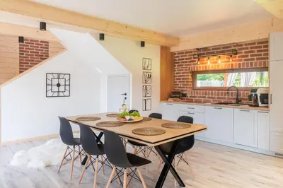 a kitchen with a wooden table and chairs at Leśna Przystań Gorce in Nowy Targ