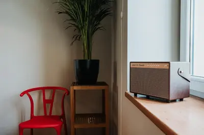 a red chair and a television on a counter with a plant at Margarita Panorama Old Town View in Kraków