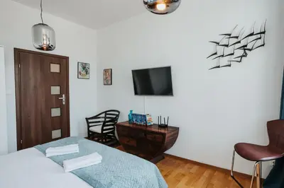 a bedroom with a bed and a tv on a wall at Margarita Panorama Old Town View in Kraków