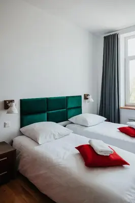 two beds in a bedroom with a green headboard at Margarita Panorama Old Town View in Kraków
