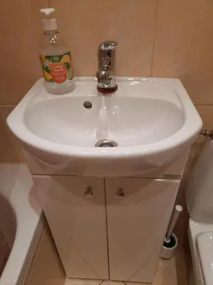a white bathroom sink with a soap bottle on it at Apartament Sofia in Kraków
