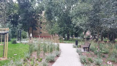 a park with a bench and flowers and a walkway at Apartament Sofia in Kraków