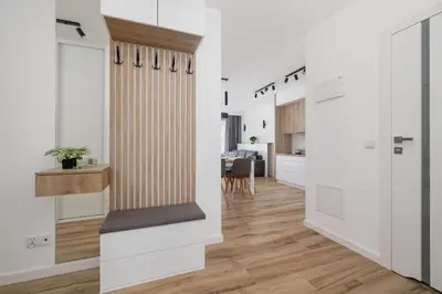 a kitchen with white walls and a wooden floor at Nowoczesny Apartament z Parkingiem na Alei Pokoju w Krakowie by Noclegi Renters in Kraków