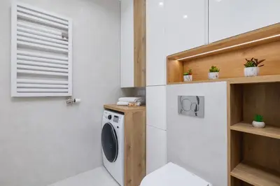 a laundry room with a washing machine and a window at Nowoczesny Apartament z Parkingiem na Alei Pokoju w Krakowie by Noclegi Renters in Kraków