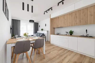 a kitchen and dining room with a table and chairs at Nowoczesny Apartament z Parkingiem na Alei Pokoju w Krakowie by Noclegi Renters in Kraków