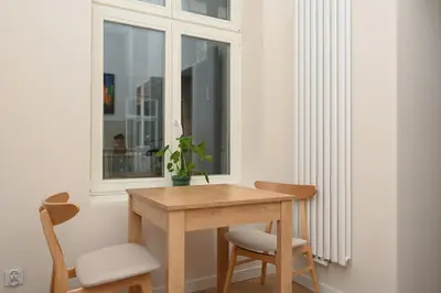 a table and two chairs in a room with a window at RentPlanet - Studio plac Matejki in Kraków