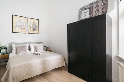 a bedroom with a black cabinet next to a bed at Dragonfly Old Town Apartment - bespoke apartments in Kraków