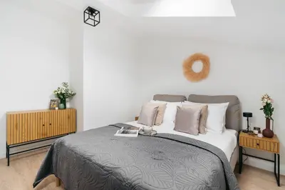 a bedroom with a large bed and two night stands at Dragonfly Old Town Apartment - bespoke apartments in Kraków