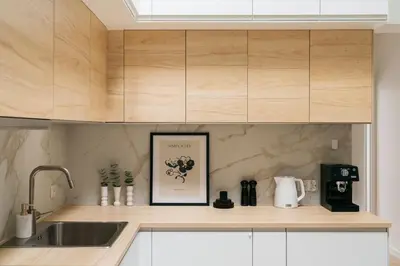 a kitchen with a sink and wooden cabinets at Dragonfly Old Town Apartment - bespoke apartments in Kraków