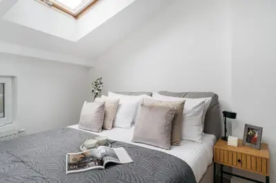 a bedroom with a large bed with white pillows at Dragonfly Old Town Apartment - bespoke apartments in Kraków
