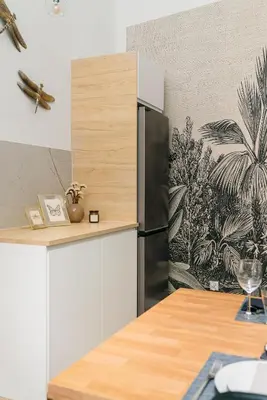 a kitchen with a refrigerator and a table with wine glasses at Dragonfly Old Town Apartment - bespoke apartments in Kraków