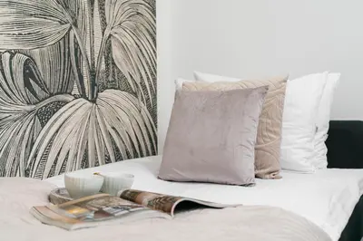 a bed with a tray with a book and two cups at Dragonfly Old Town Apartment - bespoke apartments in Kraków