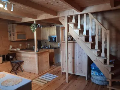 a kitchen with a spiral staircase in a log cabin at Domek za lasem in Laskowa