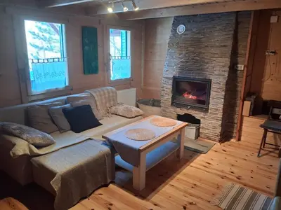 a living room with a couch and a fireplace at Domek za lasem in Laskowa